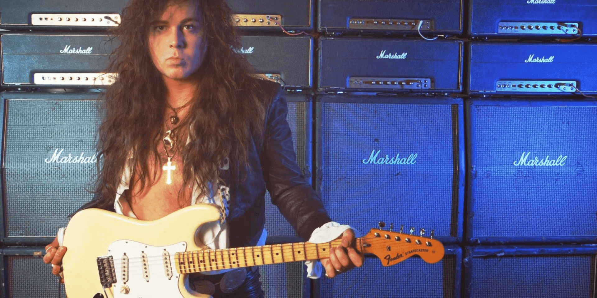 yngvie malmsteen in front of a stack of amps